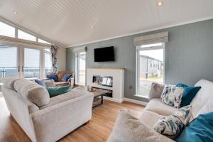 a living room with two couches and a tv at Briargate 38 in Burnham Market