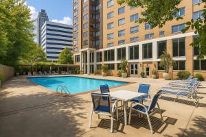 a patio with a table and chairs next to a pool at Limited Time Offer Downtown Stay Parking in Atlanta