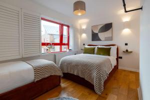 Un dormitorio con dos camas y una ventana. en Botanic House - 3BR Home - Private Parking, en Glasgow