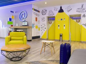 uma sala de espera com um prédio amarelo pintado na parede em ibis budget Barranquilla em Barranquilla