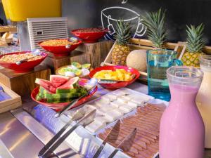 um bufê de comida com frutas e uma bebida rosa em ibis budget Barranquilla em Barranquilla