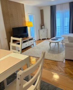 モスタルにあるBonita Apartmentsのテレビとテーブルと椅子のあるリビングルーム