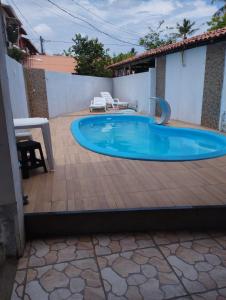 a swimming pool in a backyard with a table and chairs at Paraiso in Mata de Sao Joao