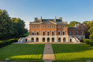una gran casa de ladrillo con un gran césped en The Stewards House at Wolterton Hall, en Itteringham