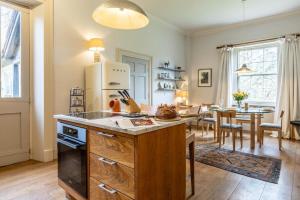 Una cocina con refrigerador y una mesa en una habitación. en The Stewards House at Wolterton Hall, en Itteringham