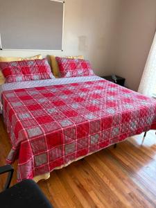 a bed in a room with a red blanket at Berni Oasis in Hampton