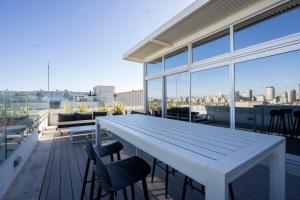 een grote witte tafel op een balkon met stoelen bij Distrito Quartier Retiro in Buenos Aires