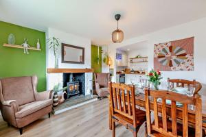 a living room with a table and chairs and a fireplace at Forest Retreat in Catcleugh