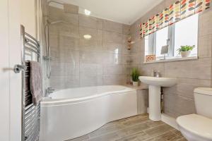 a bathroom with a tub and a sink and a toilet at Forest Retreat in Catcleugh +20 photos