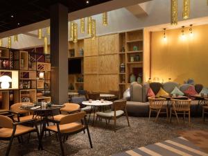 a restaurant with tables and chairs and a couch at Ibis Abdelmoumen Casa Centre in Casablanca