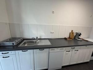 a kitchen with a sink and a counter top at Geräumige Zimmer in zentraler Lage in Prisdorf +28 photos