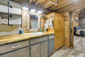 a bathroom with a sink and a mirror at Lake Eufaula Access Cozy Wood Cabin with Yard! in Coates +26 photos