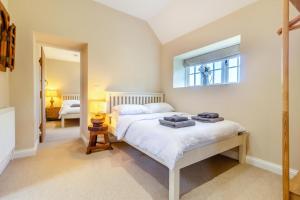 a bedroom with a bed with towels on it at The Coach House - Norfolk in Oxborough