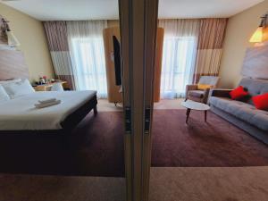 a hotel room with a bed and a couch at Ibis Aktobe in Aktobe