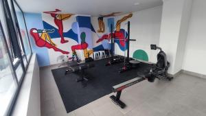 ein Raum mit einem Fitnessstudio und einem Gemälde an der Wand in der Unterkunft Departamento NUEVO de 2 dormitorios con terraza en Concepción in Concepción
