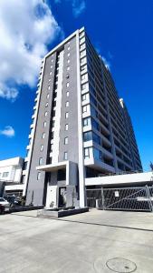 ein großes Gebäude mit einem Parkplatz davor in der Unterkunft Departamento NUEVO de 2 dormitorios con terraza en Concepción in Concepción