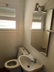 ein kleines Badezimmer mit Toilette und Waschbecken in der Unterkunft Apartament 3 habitacions i espectaculars vistes al mar in Llança