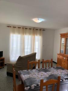 ein Wohnzimmer mit Tisch und Couch in der Unterkunft Apartament 3 habitacions i espectaculars vistes al mar in Llança + 6 Fotos