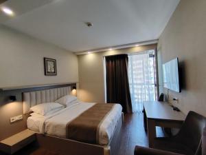 a hotel room with a bed and a desk and a computer at PANORAMA Apartments BATUMI in Batumi +53 photos