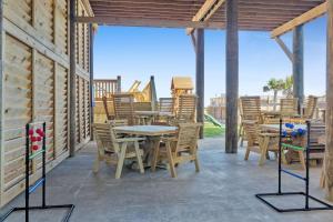 a patio with tables and chairs and a playground at Pooldreamz! Beachfront Heated Salt Pool! Sleep24! in Caplen