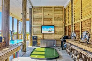 a room with a pool and a tv and a golf course at Seadreamz! Beachfront Heated Salt Pool! Sleep24! in Caplen