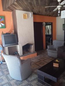 a living room with a fireplace and a tv at Sitio Vida Nova # Juquitiba in Juquitiba
