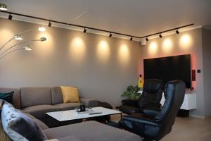 een woonkamer met een bank en een tv bij Modern apartment on Kvaløya in Tromsø