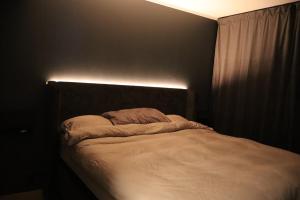 een slaapkamer met een bed met een lamp erop bij Modern apartment on Kvaløya in Tromsø