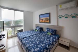 a bedroom with a bed and a large window at Reserva del Mar Resort Club de Playa in Santa Marta