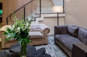 a living room with a couch and a vase of flowers at Cyan Hotel de Las Americas in Buenos Aires