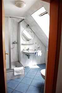 uma casa de banho com um lavatório, um chuveiro e um WC. em Breer S Hotel em Schwerte