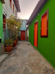 an alley with green and orange buildings and plants at Casa Bromélia in Lençóis
