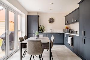 a kitchen with blue cabinets and a table and chairs at Double Room in Luxury High Trees Development in Donaghadee