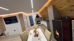 a kitchen and dining room with a table and chairs at Riverside A-frame in Borşa