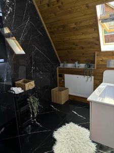 BorsaにあるRiverside A-frameの黒大理石フロアのバスルーム(シンク付)