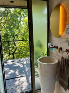 a bathroom with a large tub next to a sliding glass door at Furo Treehouse in Barajevo +15 photos