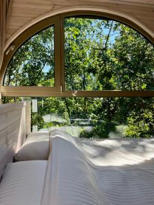 an open window with white beds in front of a window at Furo Treehouse in Barajevo
