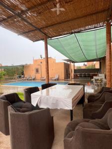 a patio with a table and chairs and a pool at Relaxing & hammam Pool Villa, 40 min to Marrakech 
