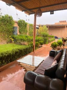 a couch sitting on a patio with a glass table at Relaxing & hammam Pool Villa, 40 min to Marrakech  +6 photos