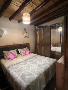 a bedroom with a large bed with pink pillows at Relaxing & hammam Pool Villa, 40 min to Marrakech 