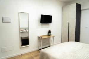 a bedroom with a bed and a mirror at Orfeo Guest House in Modugno