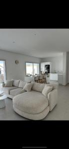 Awlād ‘UmarにあるVilla familiale piscine privée Djerbaの白い広いリビングルーム(大きなソファ付)