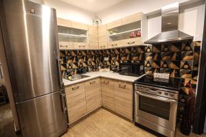 Una cocina con electrodomésticos de acero inoxidable y gabinetes de madera. en NEW COZY home ATHENS heart KYPSELI !, en Atenas 55 fotos más