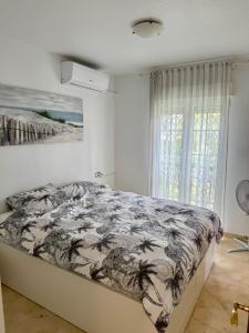 een slaapkamer met een bed met een dekbed erop bij Private Solarium - Golf and Pool View - Las Ramblas 830 in Orihuela-Costa