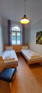 ミュンジンゲンにあるÜbernachten im Münsinger "Albgut" - Hotelzimmer, Ferienwohnungen und Stubenのベッドが2つと窓のある部屋