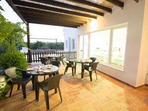 a patio with tables and chairs and windows at Tavira Monte in Tavira