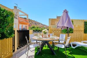 a table and chairs with an umbrella on a patio at La huerta centro in Alicante