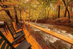 una terraza de madera con 2 bancos y un río en Creekside - 7 Min to Park 20 Min to Gatlinburg, en Cosby