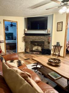 un soggiorno con divano e camino di Black Bear Hideaway a Pickens