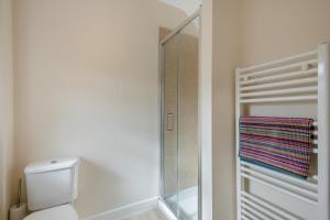 Un baño con inodoro y ducha a ras de suelo. en Little Bunting, en Heacham